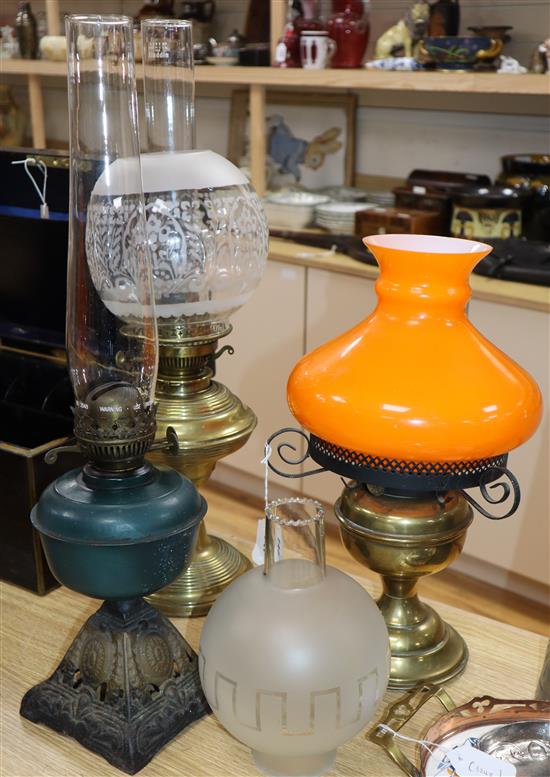 Three oil lamps, two with shades and a spare matching shade tallest 60cm